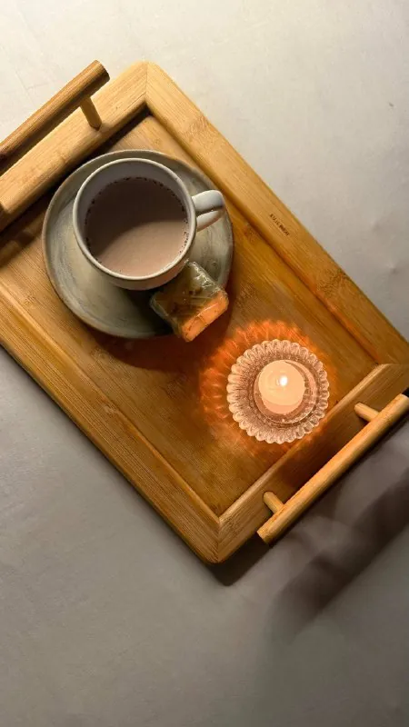Bandeja de madeira com café e vela acesa servida no Espaço Matú