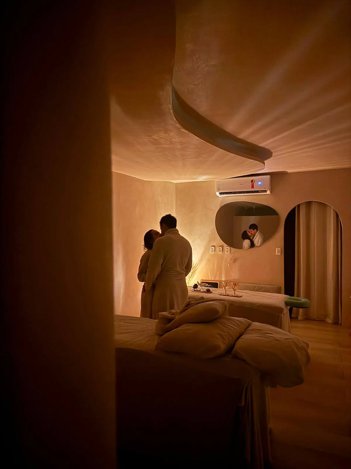 Casal abraçado em sala de massagem com luz âmbar no Espaço Matú