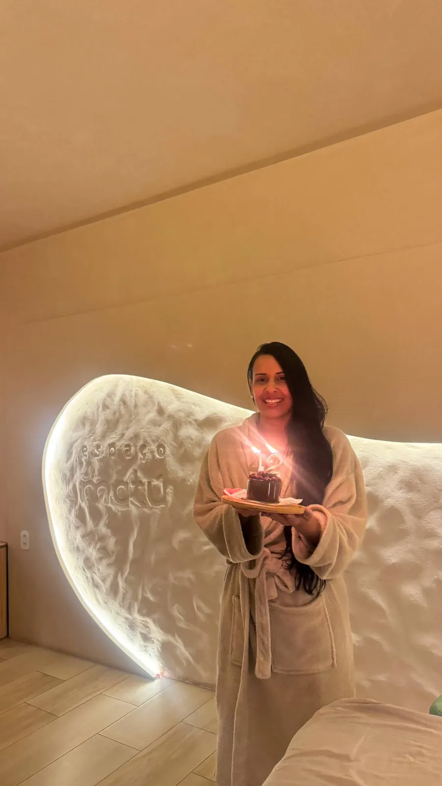 Bolo de aniversário com velas douradas em ambiente aconchegante do Espaço Matú
