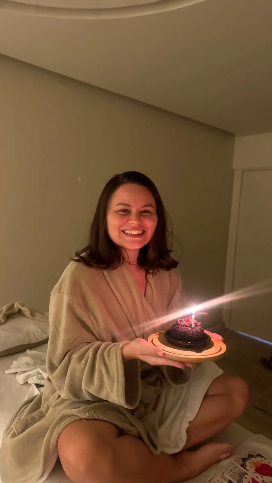 Mulher sorrindo segurando bolo de aniversário no Espaço Matú