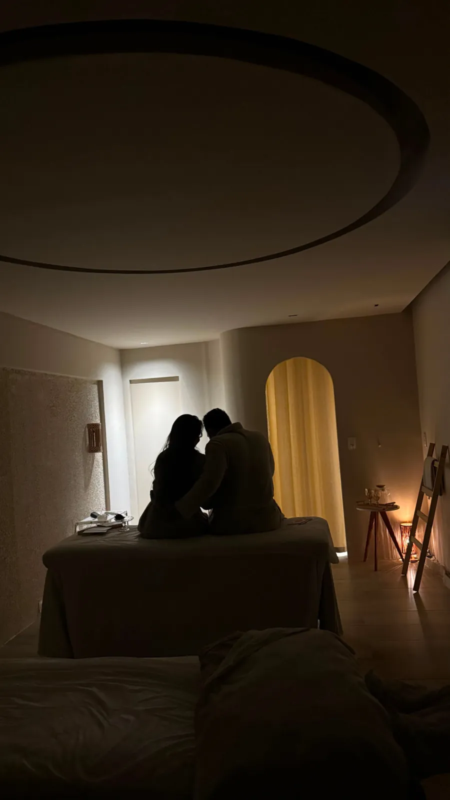 Casal sentado na maca em sala de luz baixa do Espaço Matú