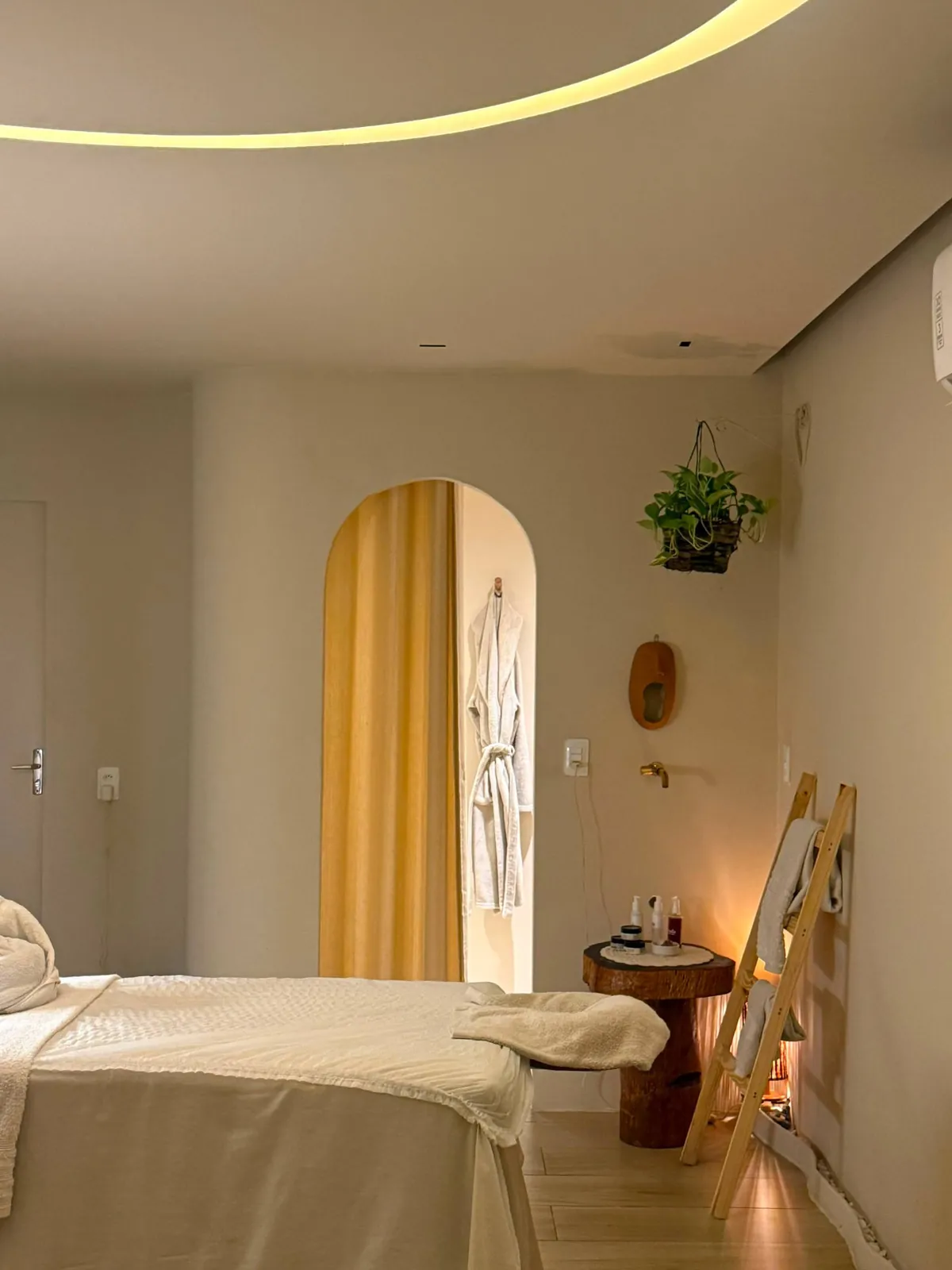 Sala terapêutica com maca, arco iluminado e roupão
